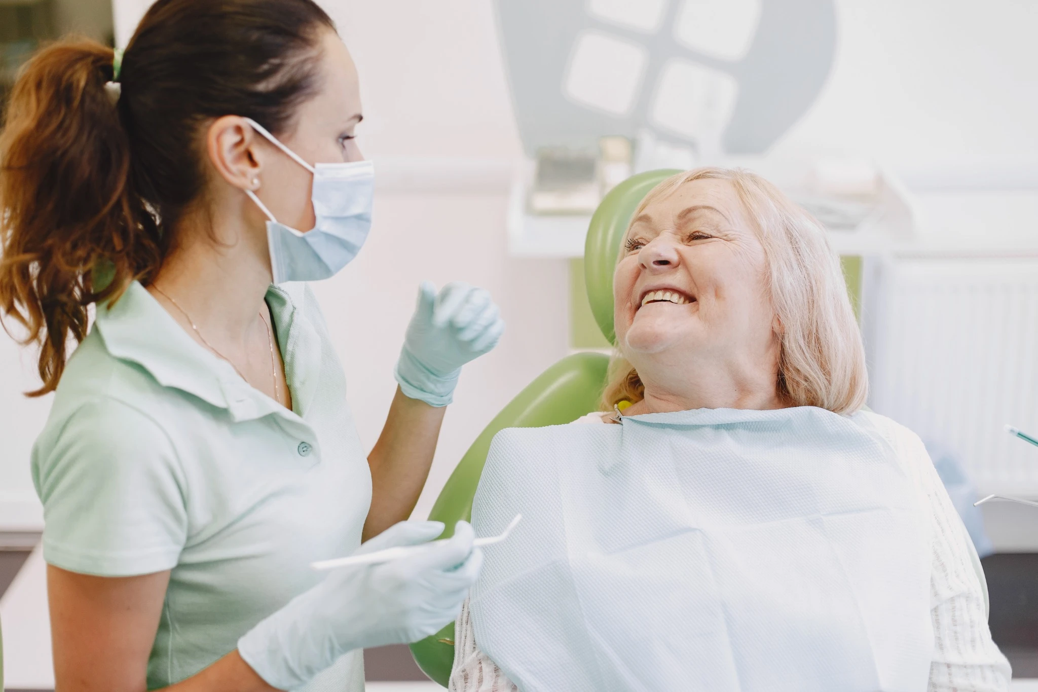 Smiling senior woman receiving dental care at a Fresno clinic, highlighting oral care for seniors