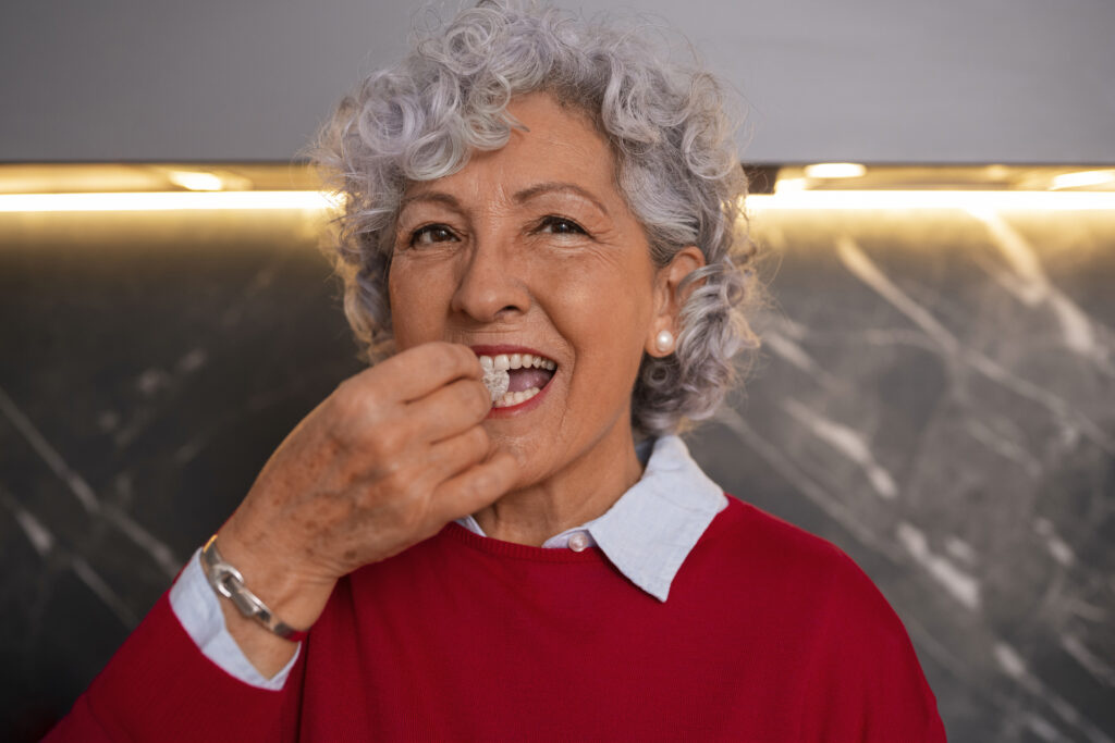 Senior woman enjoying food confidently after full mouth dental implants in Fairfield